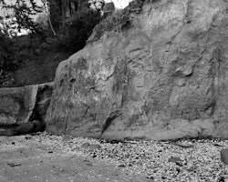 The cliff face at Rāpaki beach has been carved into by locals and visitors for generations. This part of the beach, directly in front of the church and burial ground, is considered tapu. When a member of the community passed away their clothing and bedding would be burnt here at low tide.