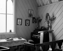 Together the people of Rāpaki built the Whare Karakia, including painting the exterior and the interior. Today the building remains in a similar condition it did one hundred and fifty years ago. Inside the Whare Karakia woven matts line the aisle and hand made cushions rest on the pews. At the altar lays open a Māori bible resting on a rock. On the wall hang portraits of past reverends.