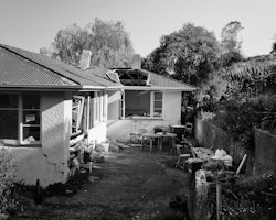 Many homes beneath Te Poho-o-Tamatea were damaged in Christchurch’s February 2011 earthquake. As a result of rock fall damages, the majority of properties directly under the peak have been deemed red zone. Rocks from Te Poho-o-Tamatea still lay in the bedroooms and lounge of this condemned home.