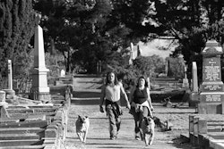 Paul: I was raised in Linwood and lived here all my life. Our boy’s been raised here as well, so him and me, we’ve got something in common. Same sorts of memories but at different times. When I was a kid I used to go over there and play in the cemetery, build huts and play war with my mates. Most of them live around the area still. There’s something about this area – we just like living here. I met my wife fourteen years ago in a nightclub. Spotted her on the other side of the floor and thought, oh yeah, she’s good-looking. We just looked at each other – had the glance sort of thing – and finally I had enough balls to go up and speak to her. It snowballed from there. Now we’re a family, undisputed love, no matter what. Life is short, real short – most of my time is spent working, forty to fifty-five hours a week. If I could, I’d spend all my time with my wife and boy. I don’t want to waste it. The cemetery is the place we go to spend time together, just walk the dogs and be by ourselves. You have this activity around you all the time now, a life of noise, but you get up there – it’s raised up on a small hill – and it’s like the whole world is behind you. It’s peaceful. There’s a sort of respect for the place. You can look over the whole of Linwood to the things we’re familiar with. Every second person that walks down the street I know. Real people. People who will help each other. It’s probably why I’ll live here till the end. Everything about it is me. I suppose you could say it’s my comfort zone. Jo: Yeah, it was a nightclub – a hotel – and I thought, hmm, he’s not bad. He was sitting by the door and I was by the dance floor in the middle of the room. The way I looked, I must have stood out to him. It was good. I’d seen him the weekend before, actually. We kept bumping into each other at different places, so I think it was meant to be. Definitely. I knew that straight away. My soulmate. I’ve always known what I wanted from life. I know that love can be short – our lives are short. I try to tell my friends that, when they’re having a little whinge about things. Hey, look at the big picture! We’ve got our health, our families, just keep moving. You get these bumps and cracks in the road, but you’ve just got to jump over them and keep going up the hill. Paul and I have a good marriage. He’s my best friend. When he gets home from work I can’t wait to see him. Like most people, we’ve been up and down, but once you’ve been down – and you come back up again – you learn. Why did that happen? And you never go back there again. You put the effort in. Try your best to care for one another. We started going up to the cemetery about twelve years ago. It’s something we do together. It’s brilliant how you can look out on the world from up there. The dogs love it too. We usually do a couple of blocks around the place and then have a wee sit on the hill. Just sit and talk about our day, tell a secret or two. Usually there’s no-one else around, just us and the dogs. Just a place for me and Paul. It might seem an unusual place to other people, but that’s just us. When the time comes, I’d like Paul and I to be buried there. Then we’d always be together in this place. That would be nice.