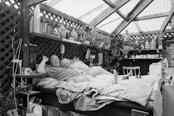 Cliff: We virtually live in this snuggle-up place here. It’s the great joy of going to bed at night. We’re not ones to be watching the television, hardly go into the house at all. More a glass of wine and doing our small talk. Lying back there and taking our ease, looking out to the night sky and the wonder of it all. This is what man has lost – the ability to wonder. He puts out the electric light and goes to sleep. We light a candle and cuddle up under the heavens. In the morning I’m looking out through the wide-open door there, straight out to the flowers and the greenery and the nectarines on the tree. I was born in Wales – in the valleys. The Avon valley to be precise. A grim place – bleak in winter, short summers. That’s why I treasure this place. The alternative to the coal mines was the merchant navy. It was my way out. Only one of my family who did get out. Actually, I went back recently to see them. It was the second Christmas I’d had at home in the whole of my adult life. To be truthful with you, it just about drove me up the wall. The people are wonderful, but the rain sweeping up the valleys is diabolical. It had rained for four months solid, and then my brother had said there’s a change coming. I said, ‘Thank God for that. What’s happening?’ ‘Snow,’ he said, and he didn’t laugh. When we bought our house this whole space here was used as a barbecue area, but we are not big meat-eaters. To tell you honestly, eating meat makes me feel a violence, so we decided to call it a garden house instead. That’s when I started to make up the bed here and the other bits and pieces. I like the sense of freedom and, what’s more, we have far less housework to do. When the leaves come blowing in here – which they do – I come gunning for them. I got this great leaf-blower at PlaceMakers. Blasts them all out again, it does, no trouble. That’s about it really – easy living. Nothing to it at all. Hilary: Joy is one of my favourite words and everything about this place brings me joy. Even when the wind blows in and around the place, it takes me straight back to the wonderful camping holidays we had as kids. Tucked up in those old canvas tents with no floor and the wind coming in under the sides and blowing around your face. They were such good memories for me, and now here we are every night, that feeling of the open air and being touched by nature. It’s just so good. Modern-day living can be so detached from natural things, but we feel very attached. ‘Connected’ would probably be a better word. Just by moving from the house to a room in a corner of our garden we seem to be more connected with the world. Something as simple as getting up for a pee in the middle of the night and you look up and there in the night sky will be this beautiful huge white moon. Fantastic! How many people get to look at the sky in the middle of the night? We’re so lucky to have that. Then you wake up in the morning and your view is straight into the wonderful green green of the garden. I’m a passionate gardener. Cliff is fond of the garden too, but he’s not so . . . well, he’s enthusiastic and I have to watch him when it comes to pulling things out. I think we have each other to thank for what we have here. We both feel the same way about it, but probably neither of us would have made this space on our own. I like that about it: that it’s something we’ve created together. A lot of our friends envy it in a way, and yet I don’t think there are many people who would take it that step further. I’m not saying we’re special or anything, but I’m glad we both feel the same way about it. It is a joy to us.