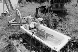 I was born in Holland and immigrated to New Zealand when I was four. I didn’t have much choice, but I’m glad it happened. I went back to Europe a couple of years ago and had a ball, but by the time I got back I was homeless and penniless – which is how I come to be living here. The cottage is on my mum’s farm. I renovated the place, did a bit of this and that, and now it’s mine. I love it. I spend a lot of time here because I’m self-employed and because I reckon home is where the heart is. I’m pretty lucky to have something I feel so good about and also to share with my friends. Actually, I got a bit of a shock when you came – when you knocked on the door – most people just come in and help themselves. The gardening started sometime before. I used to live in the city in a block of flats. There was a little piece of garden, about a metre by three hundred. It was all overgrown with weeds and I wondered what can I do with it. A friend of mine said, “Sunflowers.” I thought, brilliant. That’s what started it for me and it’s never stopped. It was all weeds around the cottage when I first got back, so I just started pulling – pull, not spray, is the motto round here. Mum’s farm is very organic. Next thing, Mum and I thought why not start a garden and sell veggies – how difficult could it be? Very, as it turned out. A lot of work. We don’t sell any more. I grow them for the love of it now and just give them away. Zucchinis are a big thing with me. Tomatoes, chillies, strawberries; spinach I love. I learned to cook in Italy and use lots of spinach. There’s nothing like it really, setting up the sprinkler on a warm evening, you can almost hear the plants sing. It’s bliss. And the bath, yeah, that’s pretty special too. My sister used to live here before me, and she had this friend of hers – a budding plumber. Mum asked him if he could hook up a tap outside, and somehow he connected it to the hot-water cylinder. There was also an old bath that’d been used at some point for the animals. I simply put the two together. More bliss. You’re lying there surrounded by the garden and the animals, the air, the sky above, you can’t hear the phone. Oh yeah, it’s heaven all right. Talking about the sky, the farm’s not too far from the airport and we do get planes coming overhead sometimes. I often try to imagine the people in them – what they might think of my garden as I lie there waving up to them.